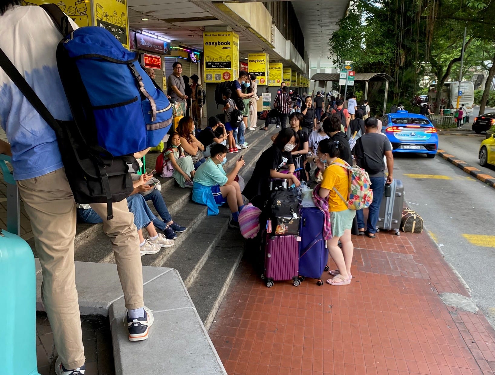 People waiting for coaches to take them across the border, mainly to different destinations in Malaysia, but also southern Thailand as well, 2022.